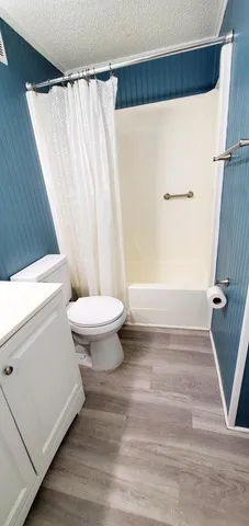 a bathroom with a sink a toilet a tub and shower