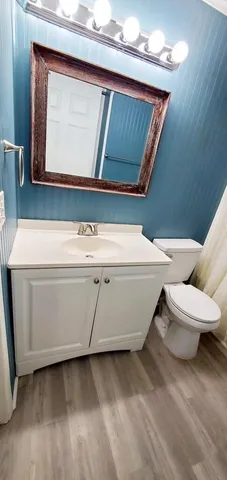 a utility room with a sink a toilet and a mirror