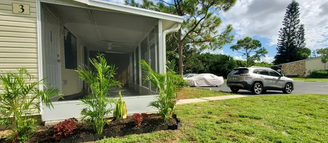 a view of a house with backyard and sitting area