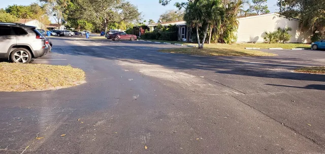 a view of a parking space with cars parked on the roadside