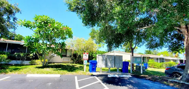a front view of a house with fountain and a tree