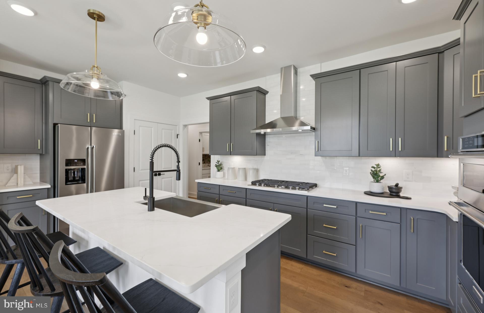 6152 Amber Lane, Unit 2 Haymarket, VA 20169 - Photo 9 of 57 a kitchen with stainless steel appliances a table chairs in it and white cabinets