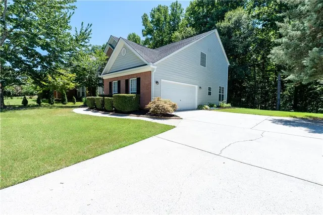 a front view of a house with a yard and trees