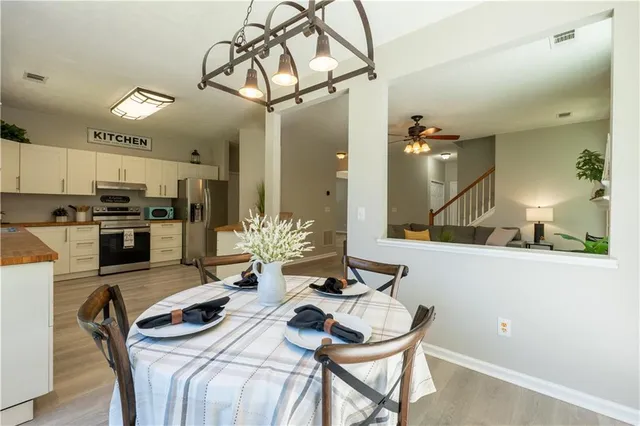 a kitchen with a table chairs stove and refrigerator