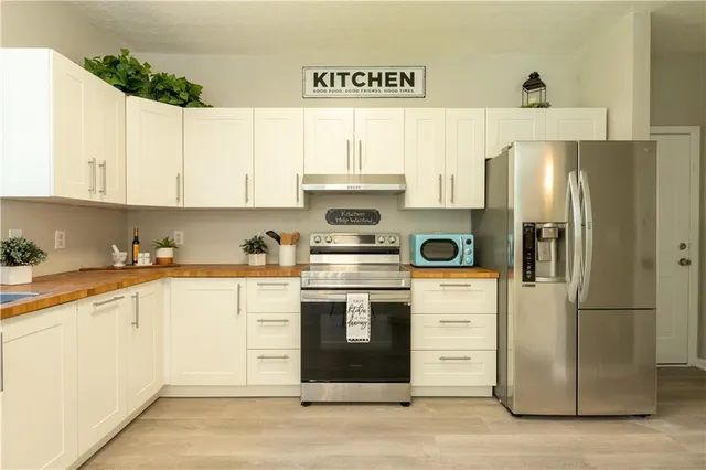 a kitchen with stainless steel appliances granite countertop a refrigerator and a stove