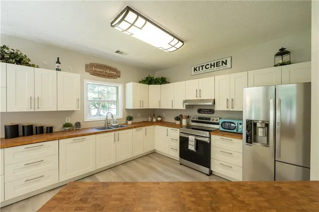 a kitchen with granite countertop a sink stainless steel appliances and cabinets