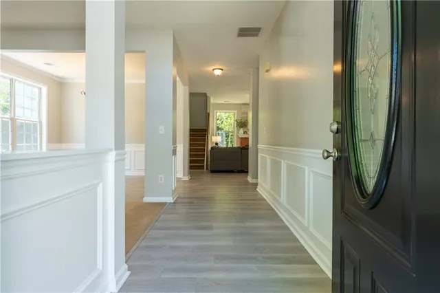 a view of a hallway with wooden floor and windows