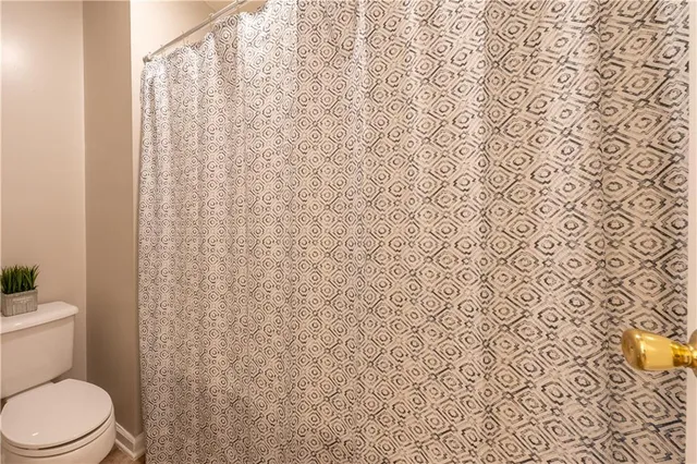 a white toilet sitting next to a shower curtain