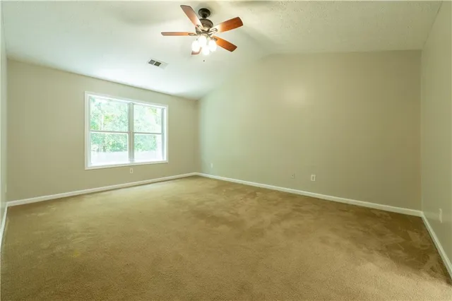 an empty room with windows and fan