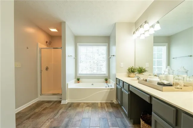 a bathroom with a tub a double vanity sink and mirror
