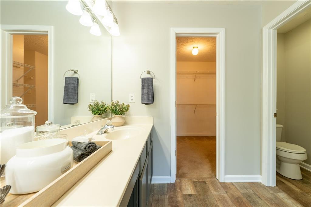 2238 St Albans Place Buford, GA 30519 - Photo 42 of 56 a bathroom with a granite countertop sink a toilet and shower