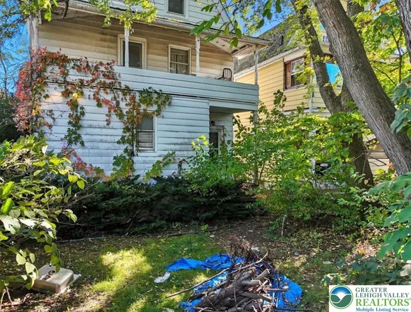 a front view of a house with a tree