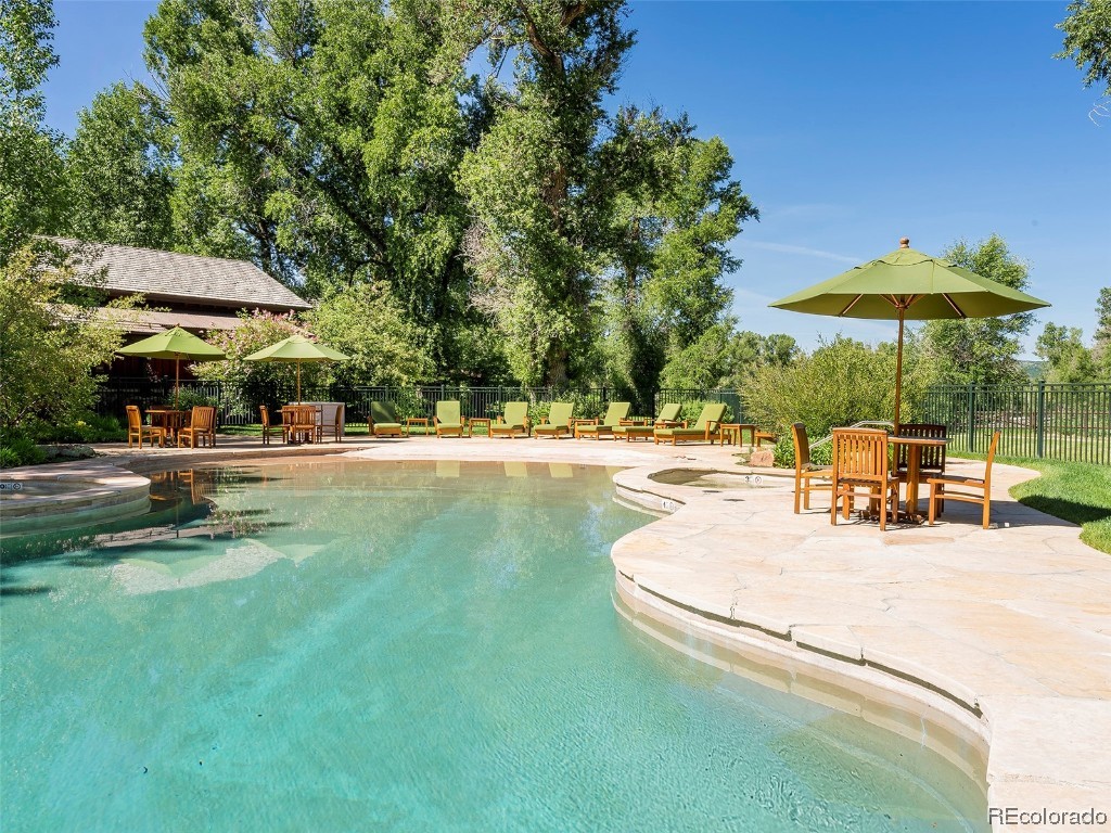 41700 Marabou Loop Steamboat Springs, CO 80487 - Photo 16 of 28 a view of a swimming pool with lawn chairs under an umbrella