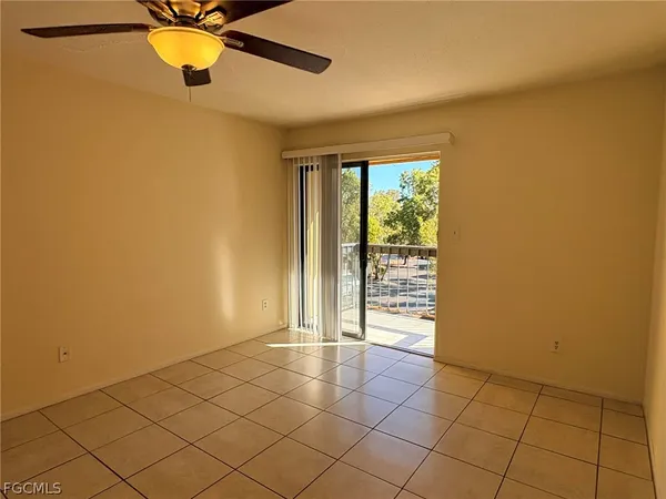 a view of an empty room with chandelier fan and fire place