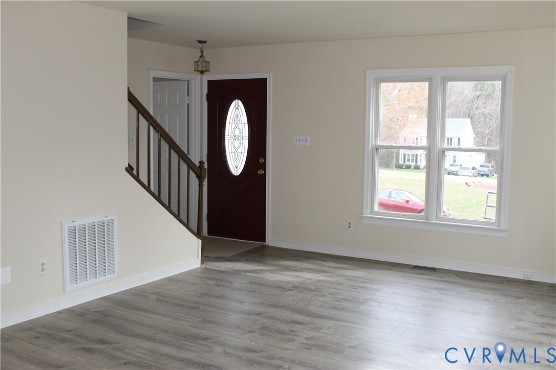 13909 Sagebrook Road Midlothian, VA 23112 - Photo 4 of 41 an empty room with wooden floor windows and entryway