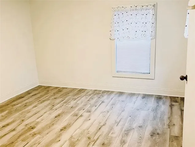 an empty room with wooden floor and cabinet