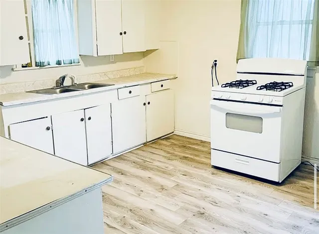 a kitchen with granite countertop white cabinets and white appliances