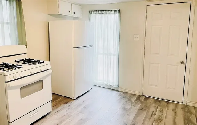 a kitchen with white cabinets and white appliances