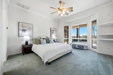 an empty room with windows and ceiling fan