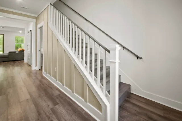 a view of a hallway with wooden floor and staircase