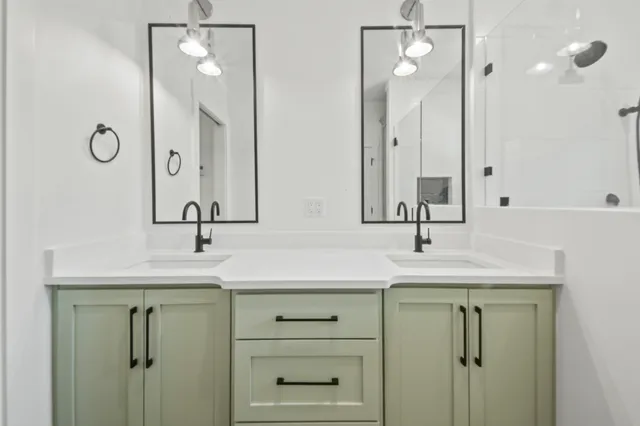 a bathroom with double sink and a mirror