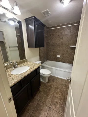a bathroom with a granite countertop sink toilet and shower