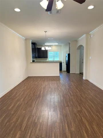 a view of a big room with wooden floor and a kitchen