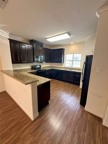 a large kitchen with wooden floors and wooden cabinets