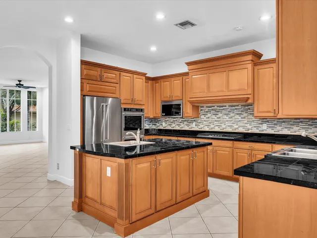a view of an empty room with kitchen view and a window