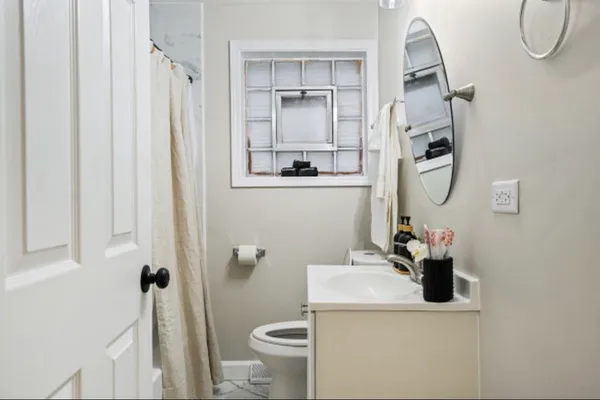 a bathroom with a sink vanity mirror and toilet