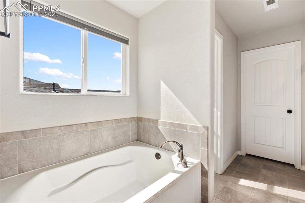 10858 Traders Parkway Fountain, CO 80817 - Photo 25 of 38 a bathroom with bathtub and window