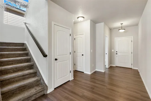 a view of a hallway with wooden floor and entryway