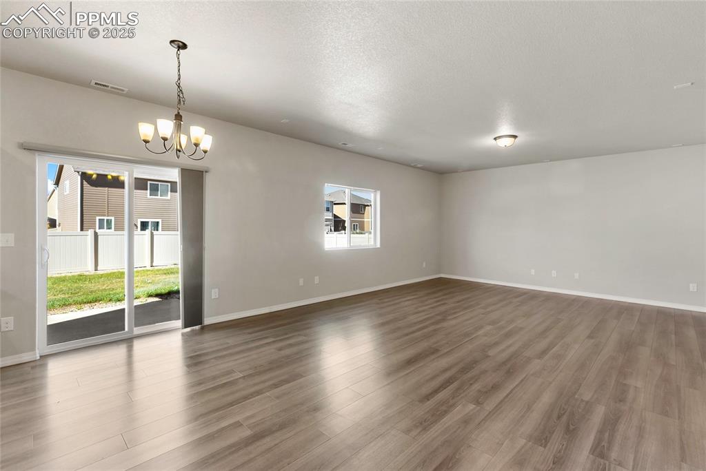 10858 Traders Parkway Fountain, CO 80817 - Photo 6 of 38 an empty room with wooden floor and windows