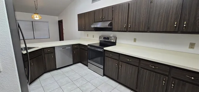 a kitchen with a sink dishwasher and wooden cabinets