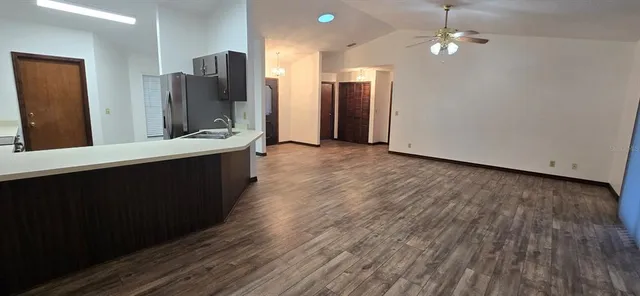 wooden floor in an empty room with a kitchen