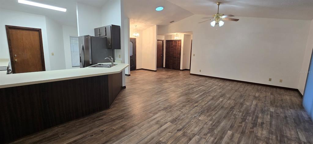 10605 Southwest 68th Terrace Ocala, FL 34476 - Photo 10 of 20 wooden floor in an empty room with a kitchen