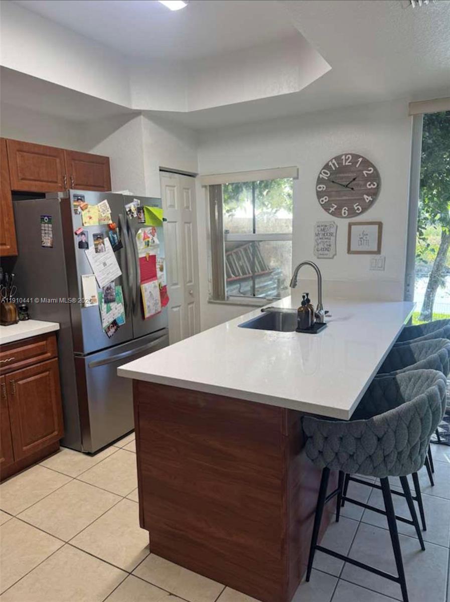 1002 Southwest 144th Avenue, Unit 605 Pembroke Pines, FL 33027 - Photo 11 of 18 a room with a table chairs and a refrigerator