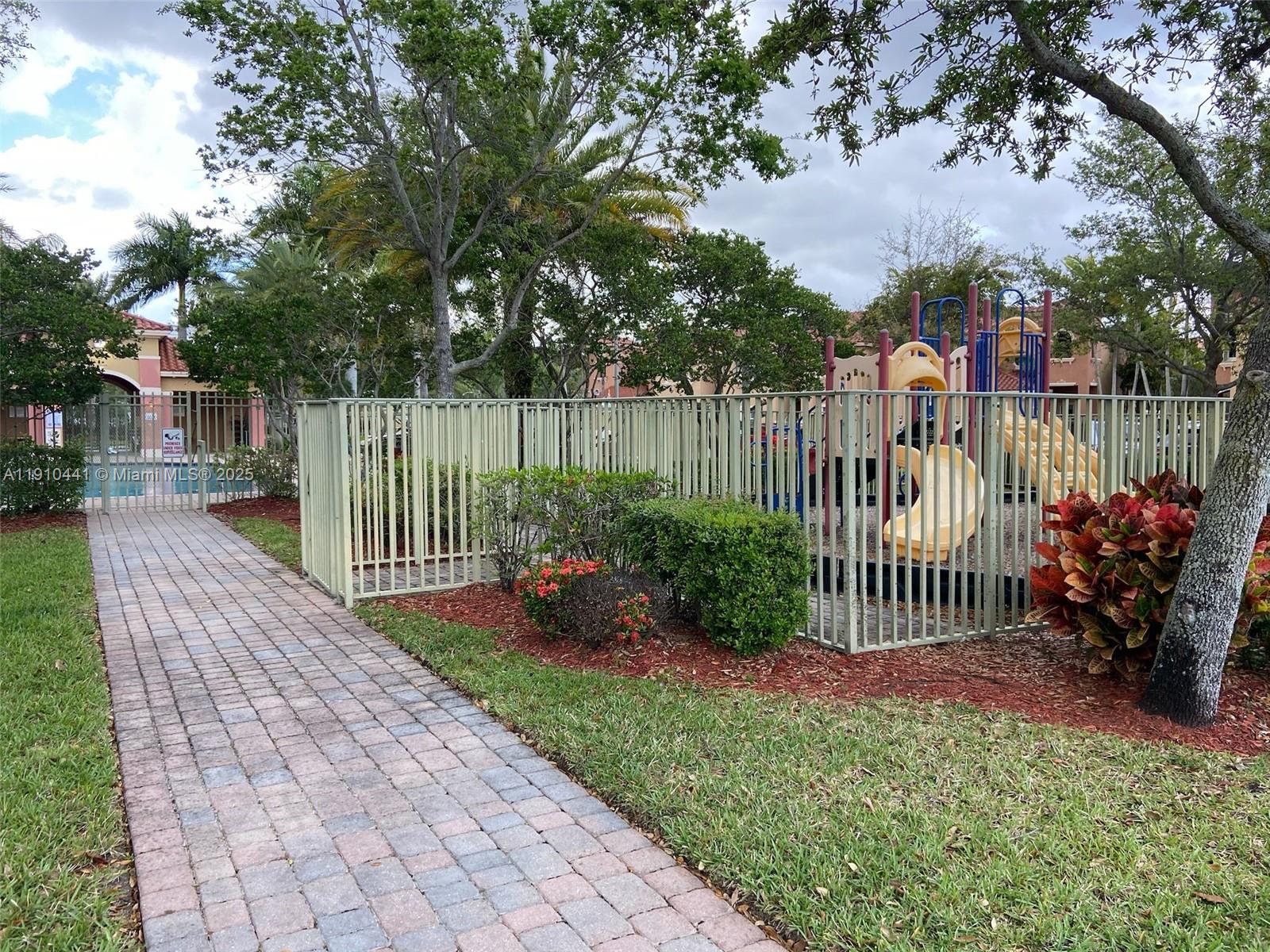 1002 Southwest 144th Avenue, Unit 605 Pembroke Pines, FL 33027 - Photo 17 of 18 a garden view with a bench in the garden