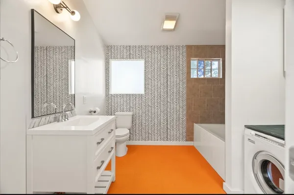 a bathroom with a sink a bathtub and a window