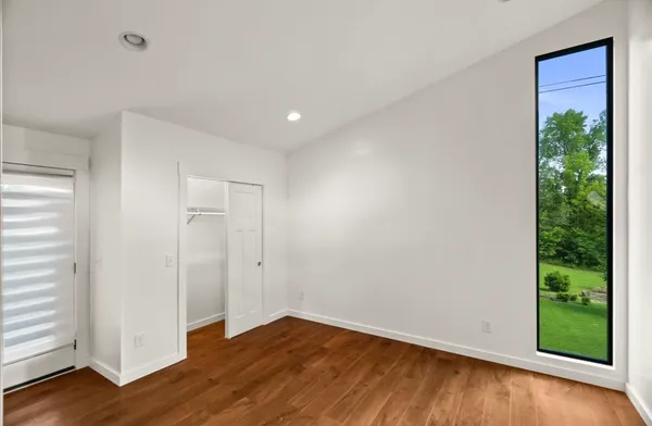 an empty room with wooden floor and windows
