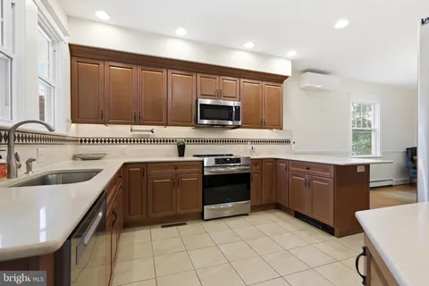 a kitchen with stainless steel appliances granite countertop a sink dishwasher stove and refrigerator