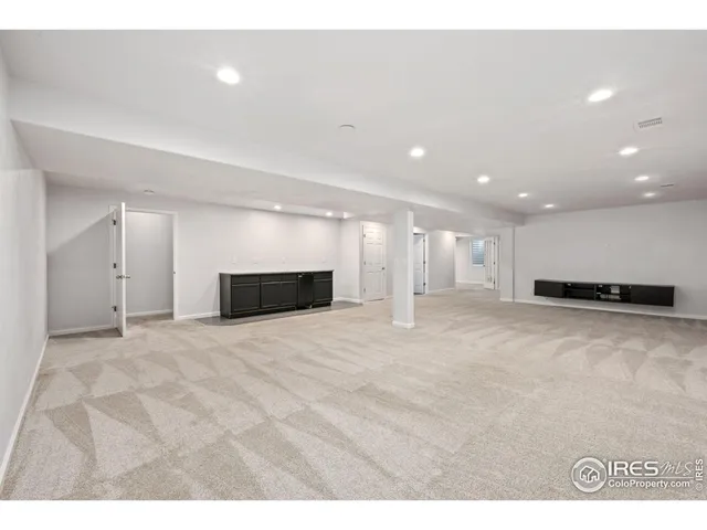 a view of empty room with kitchen