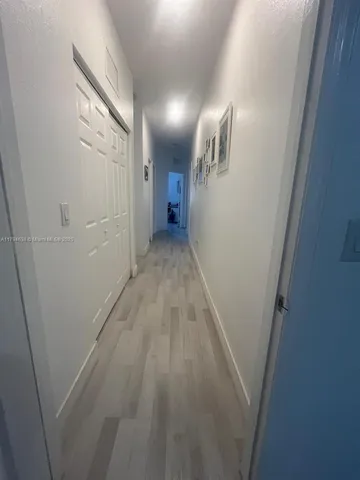 a view of hallway with wooden floor