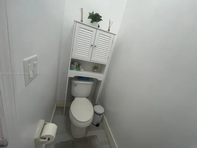 a bathroom with a toilet and a chair