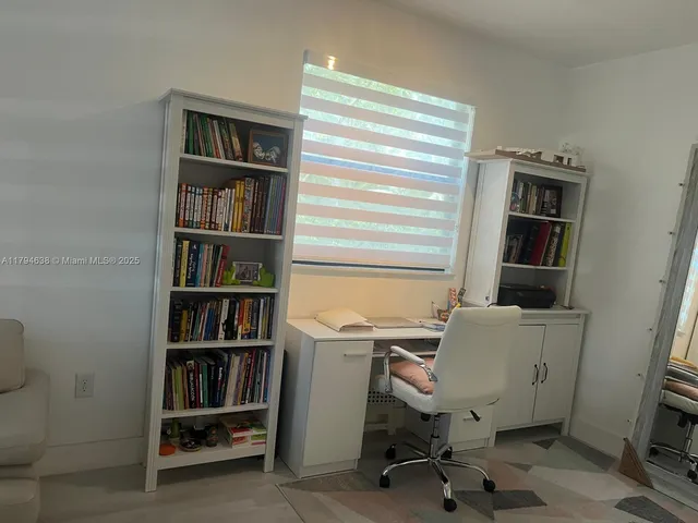 a view of a workspace with furniture and a bookshelf