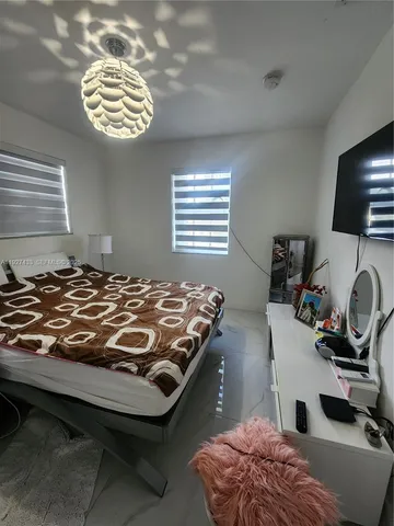 a bedroom with a bed and a chandelier