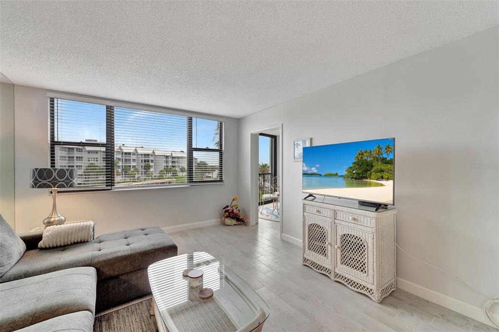5855 Midnight Pass Road, Unit 314 Sarasota, FL 34242 - Photo 16 of 58 a living room with furniture and a floor to ceiling window