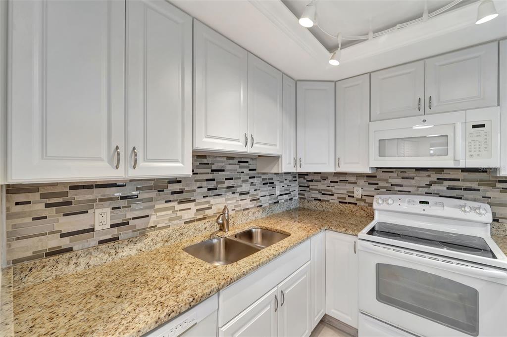 5855 Midnight Pass Road, Unit 314 Sarasota, FL 34242 - Photo 19 of 58 a kitchen with sink cabinets and stove