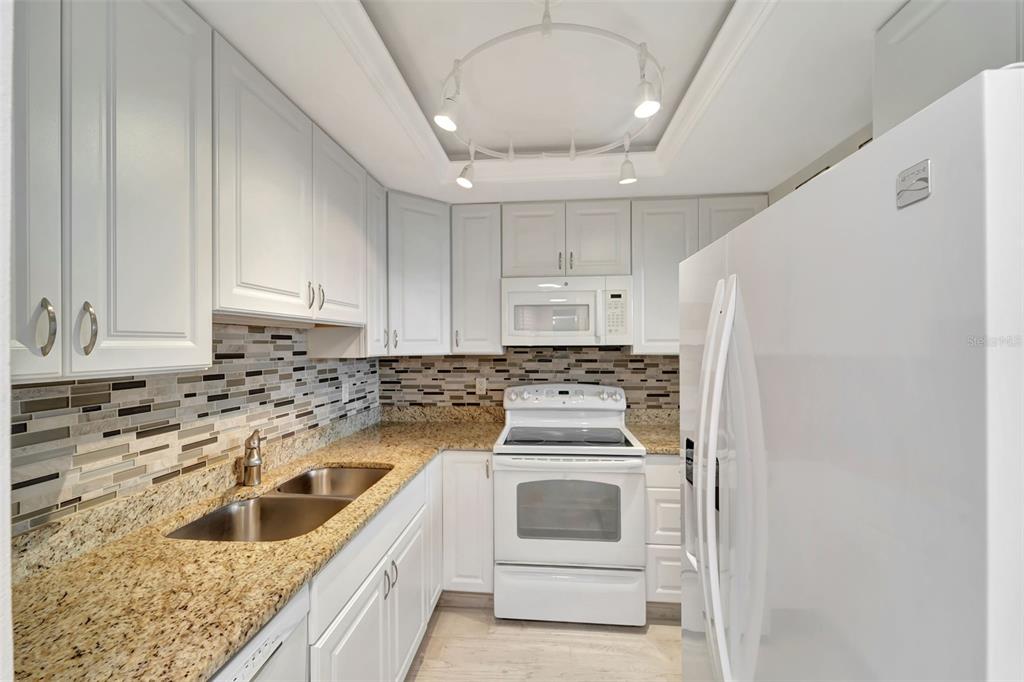 5855 Midnight Pass Road, Unit 314 Sarasota, FL 34242 - Photo 20 of 58 a kitchen that has a sink and a stove