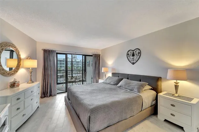 a bedroom with a bed a mirror on dresser and a chandelier